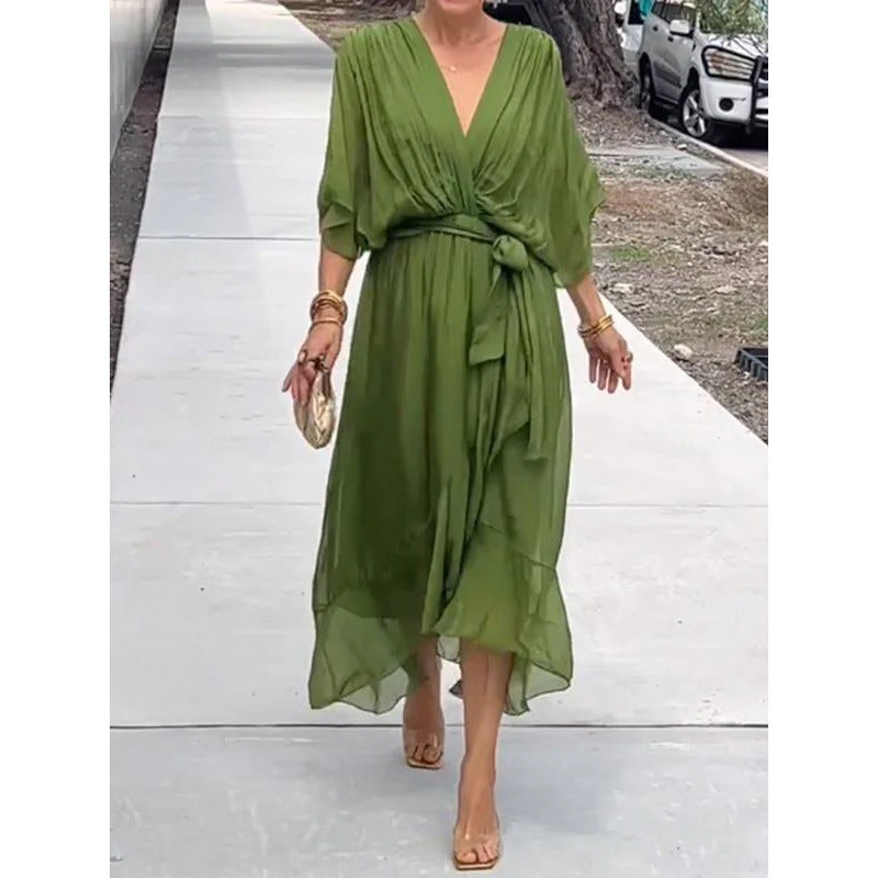 Woman wearing an elegant sage green wrap maxi dress with batwing sleeves and asymmetrical hem from Naseers Apparel